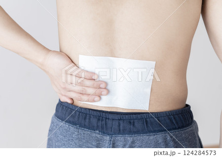 腰に湿布を貼る男性 腰痛 湿布 筋肉痛 腰に湿布を貼る男性 腰痛 湿布 筋肉痛 124284573