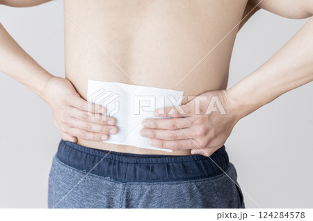 腰に湿布を貼る男性 腰痛 湿布 筋肉痛 腰に湿布を貼る男性 腰痛 湿布 筋肉痛 124284578