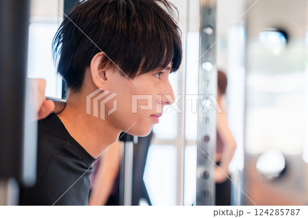 ジムで筋トレをする若い男性 124285787