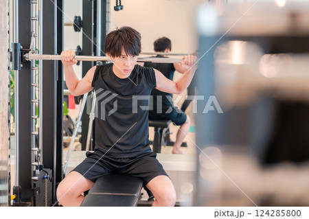 ジムで筋トレをする若い男性 124285800