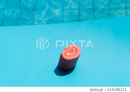 A vibrant pink cupcake adorned with a rose design sits against a playful patterned background. A vibrant pink cupcake adorned with a rose design sits against a playful patterned background. 124286121