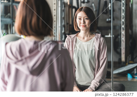 スポーツジムでストレッチ・柔軟体操する若いアジア人女性 スポーツジムでストレッチ・柔軟体操する若いアジア人女性 124286377