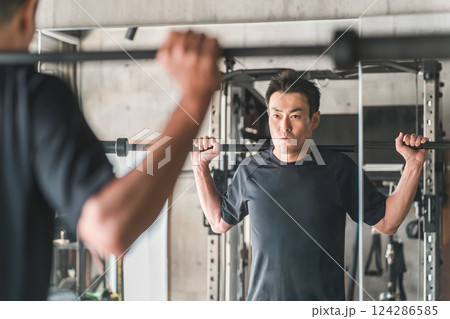 ジムでバーベルスクワットをするアジア人男性 124286585