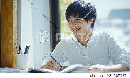 緑豊かな教室で勉強する男子学生 124287371