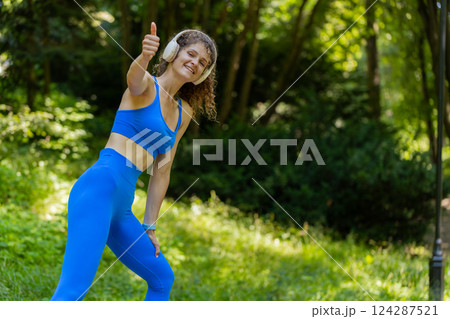 Athletic fitness sport motivated runner girl training marathon run, starting race showing thumb up Athletic fitness sport motivated runner girl training marathon run, starting race showing thumb up 124287521