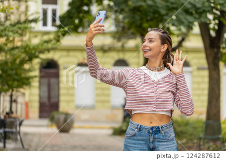 Woman blogger taking selfie on smartphone, video call online with subscribers recording stories Woman blogger taking selfie on smartphone, video call online with subscribers recording stories 124287612