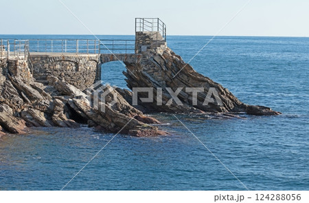 Sea and rock with walkway for tourists. Panorama and relaxation. Sunny day and calm. Sea and rock with walkway for tourists. Panorama and relaxation. Sunny day and calm. 124288056