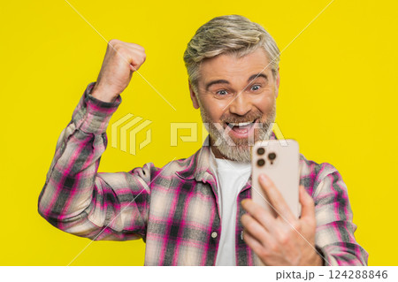 Happy excited winner man use smartphone celebrating success winning play game good lottery news Happy excited winner man use smartphone celebrating success winning play game good lottery news 124288846