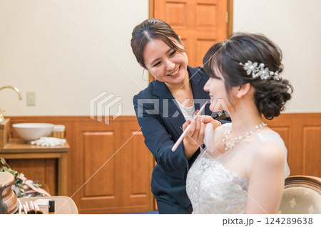 ブライズルーム・控え室で花嫁・新婦にメイクをするブライダルヘアメイクアーティストの女性(リップ) ブライズルーム・控え室で花嫁・新婦にメイクをするブライダルヘアメイクアーティストの女性(リップ) 124289638