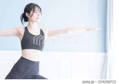 明るい部屋でフィットネスをする若い女性のイメージ 124289715