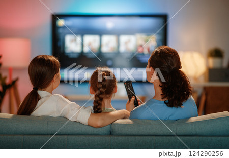 Mother and children watching TV Mother and children watching TV 124290256