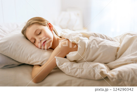 child is sleeping in the bed 124290342