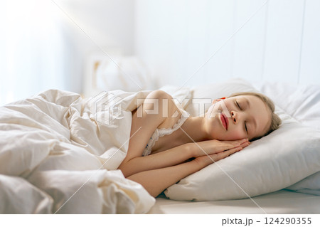 child is sleeping in the bed 124290355