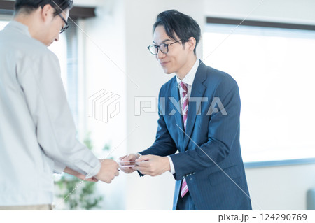 工場を訪問し名刺交換をするビジネスマン 124290769