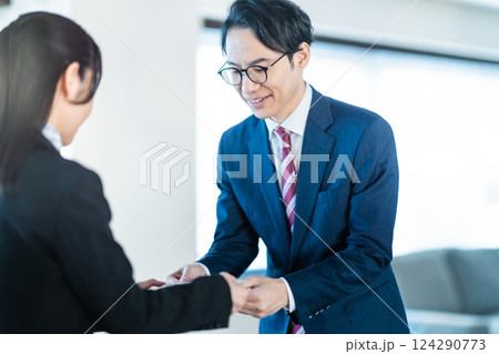 会社訪問で名刺を手渡すスーツ姿のビジネスマン 124290773