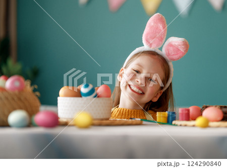 child with Easter painting eggs 124290840