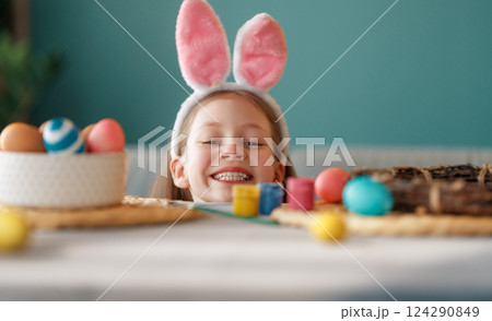 child with Easter painting eggs child with Easter painting eggs 124290849