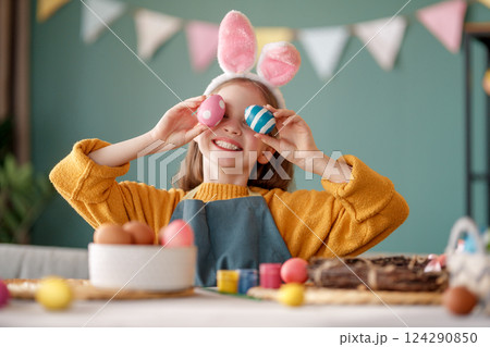 child with Easter painting eggs 124290850