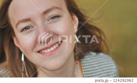 Freckled redhead beaming with joy, radiant smile capturing natural beauty in intimate close up portrait 124292062