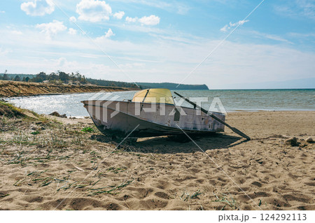 Old paddle boat stands on sand, Baikal lake shore Old paddle boat stands on sand, Baikal lake shore 124292113