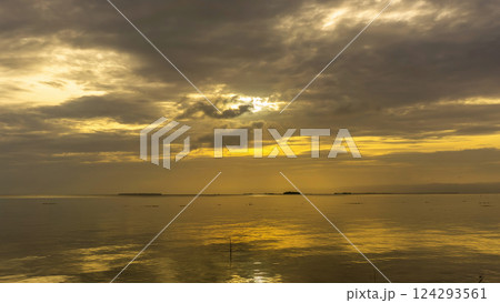 Sunset over calm waters with reflections and dramatic clouds 124293561
