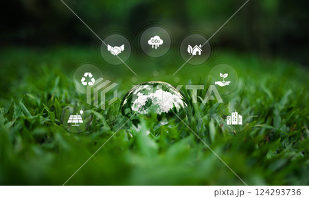 Environment and nature conservation glass ball on grass showing the world and surrounding environment icons Environment and nature conservation glass ball on grass showing the world and surrounding environment icons 124293736