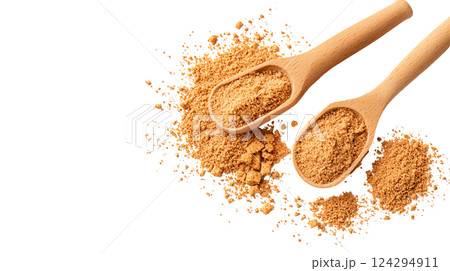 Two wooden spoons filled with brown sugar on a dark surface. 124294911