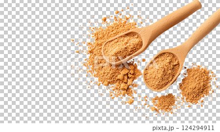 Two wooden spoons filled with brown sugar on a dark surface. 124294911