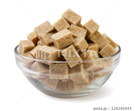 Brown sugar cubes in glass plate close-up on a white background. Isolated 124295043