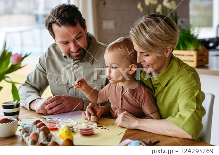 Family decorating easter eggs at home. 124295269