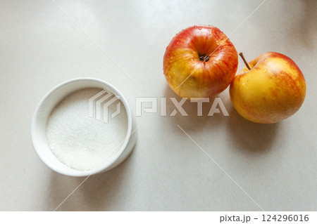 White sugar in a sugar bowl and two washed apples White sugar in a sugar bowl and two washed apples 124296016