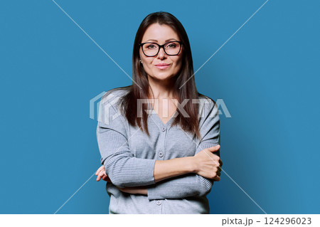 Portrait of smiling business mature woman on blue background Portrait of smiling business mature woman on blue background 124296023