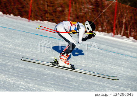 woman skier down snow-covered slope during competitive downhill skiing 124296045