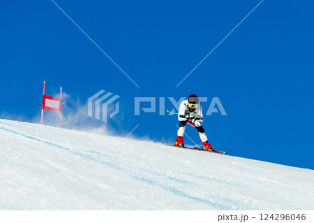 skier in whirlwind of snow down snow-covered slope during competitive downhill skiing 124296046