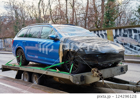 Damaged blue car on tow truck. Crashed vehicle 124296128