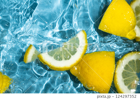 Juicy lemon background of halves and slices of fresh lemons in water. Juicy lemon background of halves and slices of fresh lemons in water. 124297352