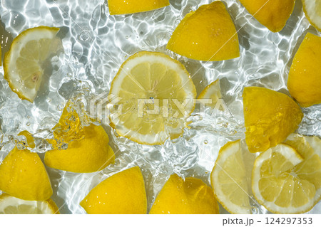 Slices of fresh lemons in water, splash of water, top view. Slices of fresh lemons in water, splash of water, top view. 124297353