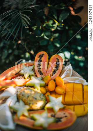 Colorful tropical fruit platter enjoyed in a garden setting on a sunny day 124297417