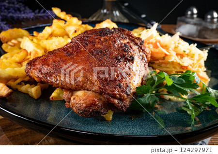Crispy roasted chicken piece with french fries and salad. 124297971