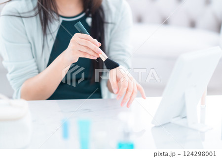 化粧筆でパウダーの色を確認する若い女性　顔無し 124298001