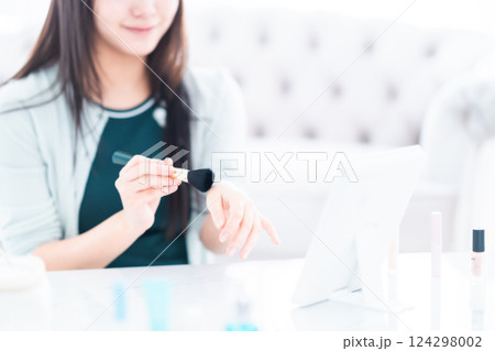 化粧筆でパウダーの色を確認する若い女性　顔無し 124298002
