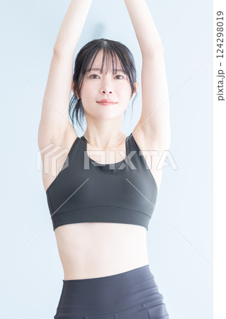 ストレッチにヨガを取り入れたトレーニング中の女性 124298019