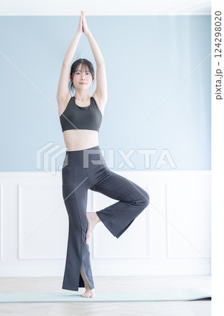 ストレッチにヨガを取り入れたトレーニング中の女性 124298020
