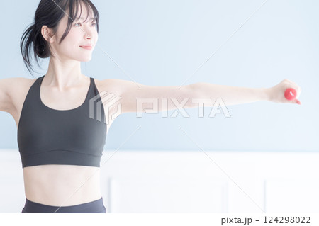 ダンベルでポーズをとるトレーニング中の女性 ダンベルでポーズをとるトレーニング中の女性 124298022