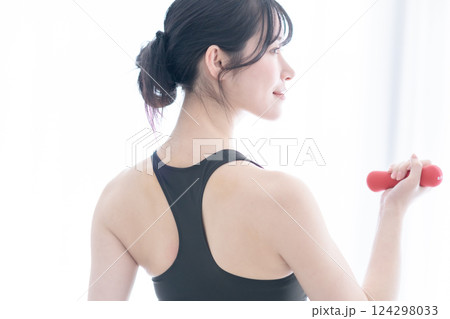 ウェイトを持ってスロートレーニングをする若い女性の背中 124298033