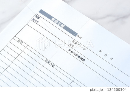毎日の業務を終えた後、所要時間や作業内容、進捗状況を報告する書類、「業務日報」を記入する 124300504