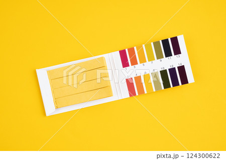 Universal indicator paper with acidic testing on yellow. Universal indicator paper with acidic testing on yellow. 124300622