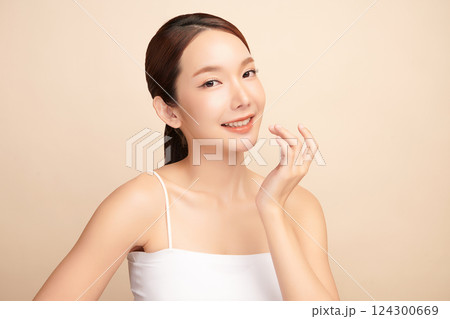 A beautiful young Asian woman with clean, fresh skin against a beige background. Skincare, facial treatment, cosmetology, beauty, and spa. An elegant portrait of an Asian woman. A beautiful young Asian woman with clean, fresh skin against a beige background. Skincare, facial treatment, cosmetology, beauty, and spa. An elegant portrait of an Asian woman. 124300669