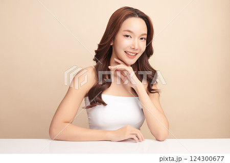 A beautiful young Asian woman with clean, fresh skin against a beige background. Skincare, facial treatment, cosmetology, beauty, and spa. An elegant portrait of an Asian woman. A beautiful young Asian woman with clean, fresh skin against a beige background. Skincare, facial treatment, cosmetology, beauty, and spa. An elegant portrait of an Asian woman. 124300677