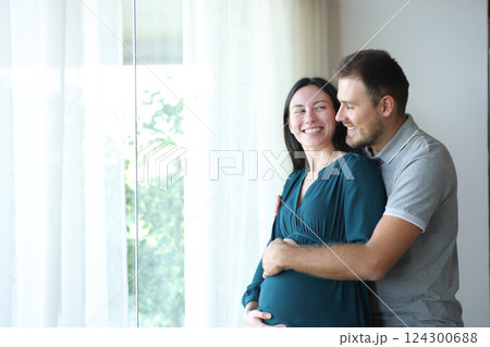 Happy pregnant asian woman looking at her partner at home 124300688